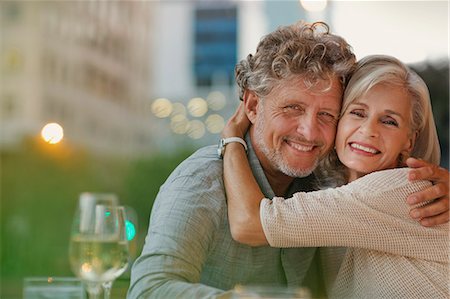 simsearch:6124-08805230,k - Portrait smiling senior couple hugging at urban sidewalk cafe Stock Photo - Premium Royalty-Free, Code: 6124-08743201