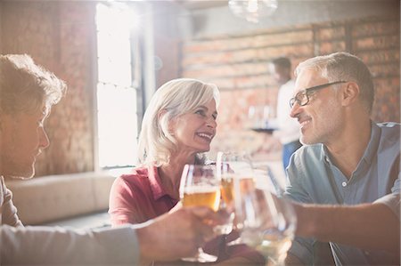 simsearch:6113-08882621,k - Smiling friends toasting beer and wine glasses in restaurant Photographie de stock - Premium Libres de Droits, Code: 6124-08743209