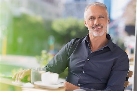 Portrait smiling man drinking coffee at urban sidewalk cafe Foto de stock - Sin royalties Premium, Código: 6124-08743227