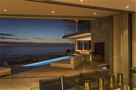 simsearch:6124-08743315,k - Illuminated home showcase patio with lap pool and twilight ocean view Foto de stock - Sin royalties Premium, Código: 6124-08743341