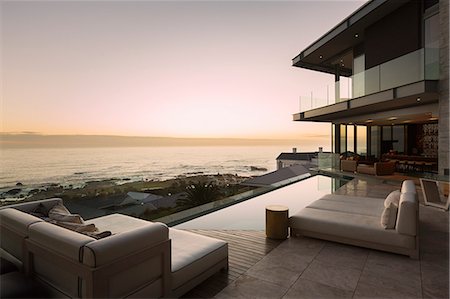 simsearch:6124-08704022,k - Tranquil sunset ocean view beyond modern luxury home showcase patio Photographie de stock - Premium Libres de Droits, Code: 6124-08743361