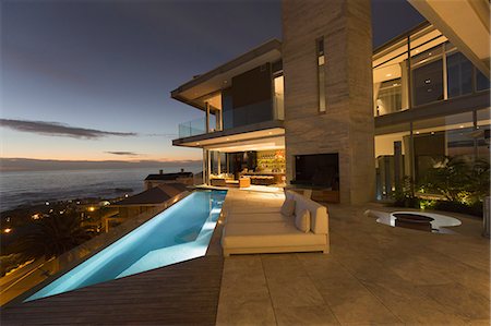 Illuminated luxury home showcase exterior and infinity lap pool with ocean view Stock Photo - Premium Royalty-Free, Code: 6124-08743306