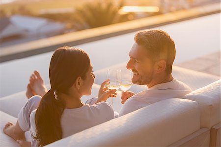 simsearch:6124-08743313,k - Couple relaxing toasting white wine glasses on chaise lounge on luxury patio Foto de stock - Sin royalties Premium, Código: 6124-08743316