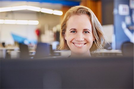 simsearch:6124-08768389,k - Portrait smiling businesswoman working at computer Stock Photo - Premium Royalty-Free, Code: 6124-08768352