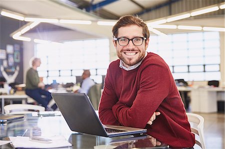 simsearch:6124-08768389,k - Portrait smiling businesswoman working at laptop in office Stock Photo - Premium Royalty-Free, Code: 6124-08768384