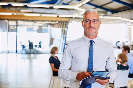 solemne - Portrait confident businessman with digital tablet in office Foto de stock - Sin royalties Premium, Código: 6124-08768394