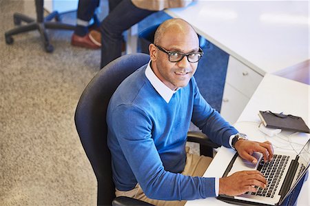 simsearch:6124-08768390,k - Portrait businessman working at laptop in office Stock Photo - Premium Royalty-Free, Code: 6124-08768416