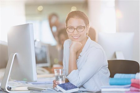 Portrait smiling businesswoman at computer in office Photographie de stock - Premium Libres de Droits, Code: 6124-08703888