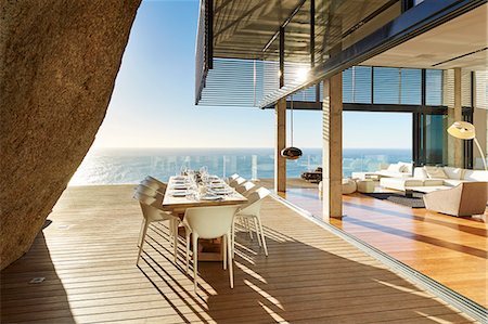 Modern luxury dining table on sunny patio with ocean view Stock Photo - Premium Royalty-Free, Code: 6124-08703992