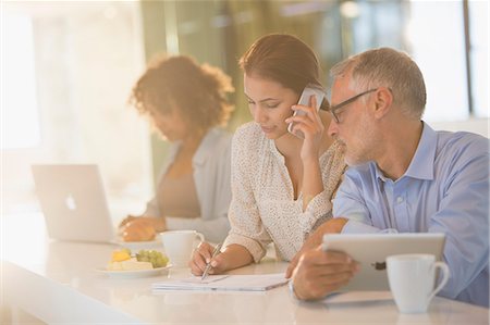 simsearch:649-06305255,k - Business people drinking coffee and working at counter Stock Photo - Premium Royalty-Free, Code: 6124-08703920