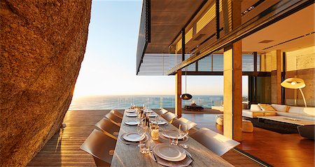 Modern luxury patio dining table with sunset ocean view Foto de stock - Sin royalties Premium, Código: 6124-08704011