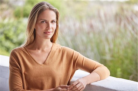 portraits, women - Portrait serene woman on patio Stock Photo - Premium Royalty-Free, Code: 6124-08805257