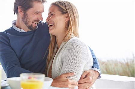 Happy couple hugging and laughing on patio Stock Photo - Premium Royalty-Free, Code: 6124-08805207