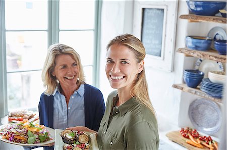 senior women kitchen - Portrait smiling mother and daughter serving food Photographie de stock - Premium Libres de Droits, Code: 6124-08805217