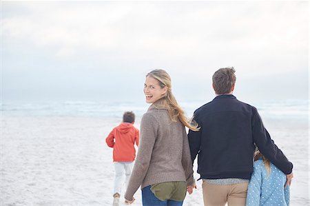 Portrait happy family walking on winter beach Stock Photo - Premium Royalty-Free, Code: 6124-08805224