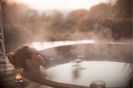 Serene woman soaking in steaming hot tub with autumn tree view Stock Photo - Premium Royalty-Free, Code: 6124-08820690