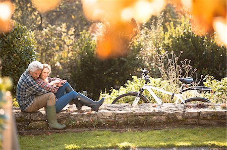 simsearch:6113-06721174,k - Affectionate couple hugging on stone wall in autumn park Stock Photo - Premium Royalty-Free, Code: 6124-08820757