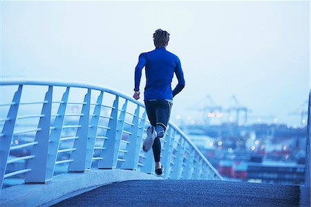 simsearch:6124-08820837,k - Male runner running on urban footbridge at dawn Photographie de stock - Premium Libres de Droits, Code: 6124-08820789