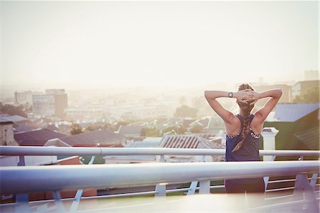 person from behind lifestyle - Female runner stretching resting on urban footbridge at dawn Stock Photo - Premium Royalty-Free, Code: 6124-08820793