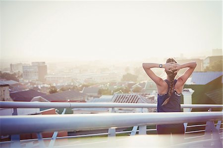 simsearch:6113-08943763,k - Female runner stretching resting on urban footbridge at dawn Photographie de stock - Premium Libres de Droits, Code: 6124-08820793