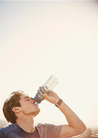 runners resting - Thirsty male runner drinking water from water bottle Stock Photo - Premium Royalty-Free, Code: 6124-08820878