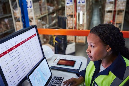 security desk - Focused female manager using laptop and computer in distribution warehouse Stock Photo - Premium Royalty-Free, Code: 6124-08820943