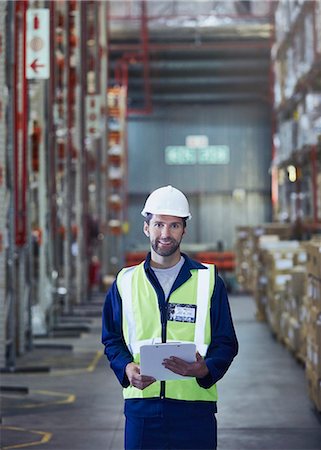 simsearch:6124-08820937,k - Portrait smiling worker with clipboard in distribution warehouse Foto de stock - Royalty Free Premium, Número: 6124-08820920