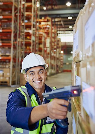 simsearch:6124-08820937,k - Portrait smiling worker using scanner scanning boxes in distribution warehouse Foto de stock - Royalty Free Premium, Número: 6124-08820930