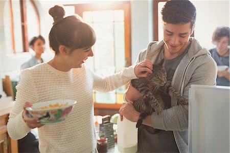 eating (animals eating) - Young couple petting cat in kitchen Stock Photo - Premium Royalty-Free, Code: 6124-08821007