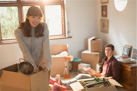 Portrait smiling young couple unpacking moving boxes in apartment Stock Photo - Premium Royalty-Free, Code: 6124-08821036