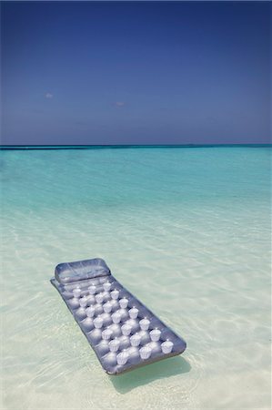 simsearch:6124-09188670,k - Inflatable raft floating on tranquil blue tropical ocean Photographie de stock - Premium Libres de Droits, Code: 6124-08945943