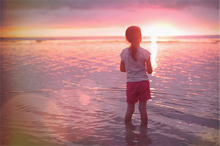 simsearch:6124-08907957,k - Pensive girl wading in ocean on tranquil sunset beach Stock Photo - Premium Royalty-Free, Code: 6124-08945957