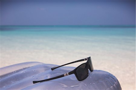 Sunglasses on inflatable raft in tropical blue ocean Photographie de stock - Premium Libres de Droits, Code: 6124-08945903