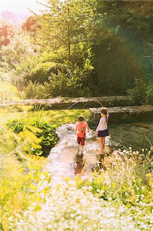 playing with hose - Boy and girl brother and sister playing with hose in sunny summer garden Stock Photo - Premium Royalty-Free, Code: 6124-08945905