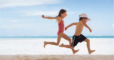 simsearch:649-08561276,k - Boy and girl brother and sister running on tropical beach Fotografie stock - Premium Royalty-Free, Codice: 6124-08945921