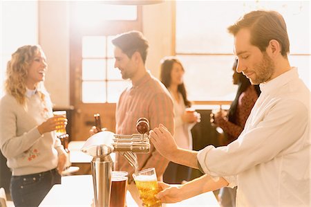 people serving food and drinks - Bartender pouring beer at beer tap behind bar Stock Photo - Premium Royalty-Free, Code: 6124-08946101