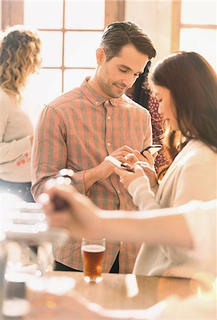 Couple texting with cell phones at bar Stock Photo - Premium Royalty-Free, Code: 6124-08946108