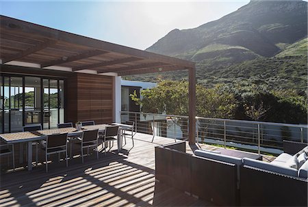 Sunny modern luxury home showcase exterior balcony patio with mountain view Stock Photo - Premium Royalty-Free, Code: 6124-08907960