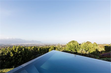 simsearch:6124-08907999,k - Modern, geometric infinity pool with sunny view under blue sky Stock Photo - Premium Royalty-Free, Code: 6124-08907987