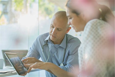 simsearch:6124-08908078,k - Male doctor showing digital tablet to female patient in doctor’s office Stock Photo - Premium Royalty-Free, Code: 6124-08908080