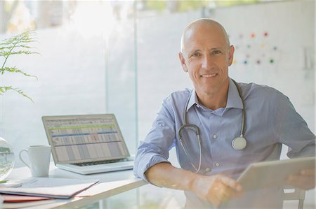 portable computer - Portrait smiling male doctor with digital tablet in doctor’s office Stock Photo - Premium Royalty-Free, Code: 6124-08908094