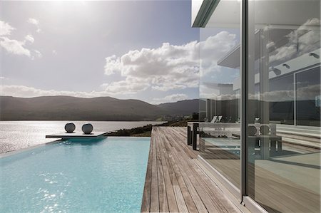 pool without people - Sunny, tranquil modern luxury home showcase exterior with infinity pool and ocean view Photographie de stock - Premium Libres de Droits, Code: 6124-08908197