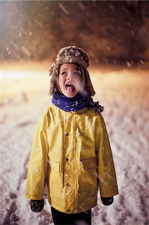 sticking out tongue in snow - Boy in warm clothing sticking tongue out, tasting snow Stock Photo - Premium Royalty-Free, Code: 6124-08908253