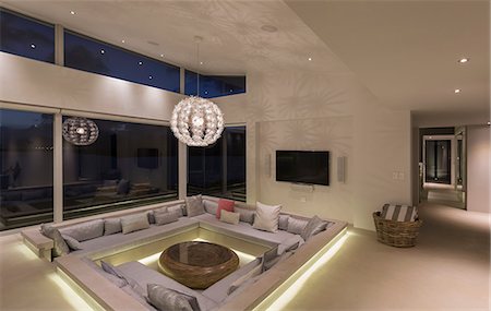 simsearch:6113-08722099,k - Illuminated modern luxury home showcase interior living room with chandelier Stock Photo - Premium Royalty-Free, Code: 6124-08908226