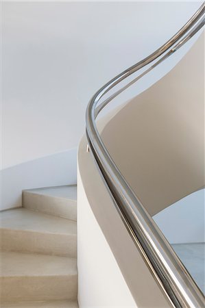 Stainless steel railing along spiral staircase in home showcase interior Foto de stock - Sin royalties Premium, Código: 6124-08908234