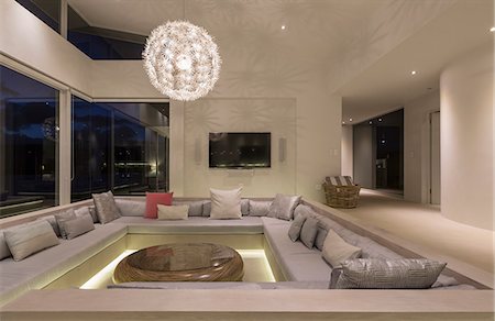 simsearch:6113-07589580,k - Illuminated modern luxury home showcase interior living room with chandelier Foto de stock - Sin royalties Premium, Código: 6124-08908238