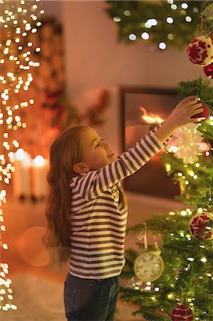 decorating tree - Girl hanging ornament on Christmas tree Foto de stock - Sin royalties Premium, Código: 6124-08926969