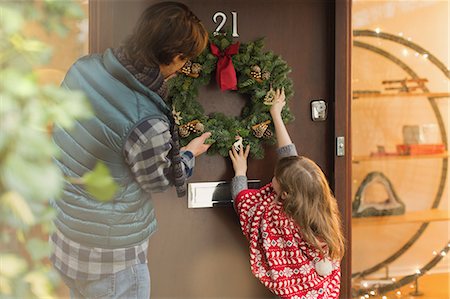 simsearch:700-02686624,k - Father and daughter hanging Christmas wreath on front door Foto de stock - Sin royalties Premium, Código: 6124-08926978