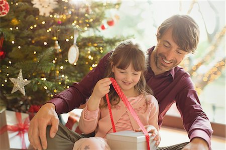 simsearch:6108-05874752,k - Father watching daughter opening Christmas gift Photographie de stock - Premium Libres de Droits, Code: 6124-08926983
