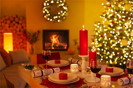 simsearch:628-05817804,k - Ambient candles and Christmas crackers on dinner table in living room with fireplace and Christmas tree Stock Photo - Premium Royalty-Free, Code: 6124-08926986